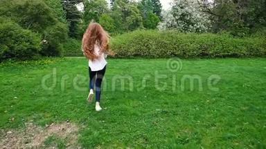 长卷发的欧洲女孩<strong>带</strong>着肥皂泡在公园里奔跑。 很长的头发随风<strong>飘动</strong>，慢慢地